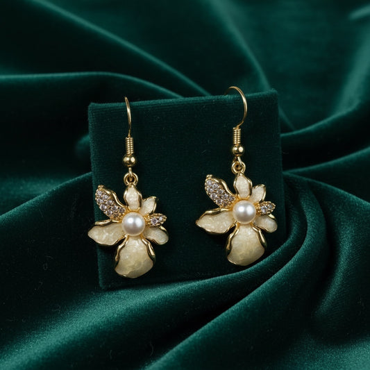 Charmluna floral hook earrings featuring mother of pearl petals, crystal accents, and a central pearl on gold-tone wire.