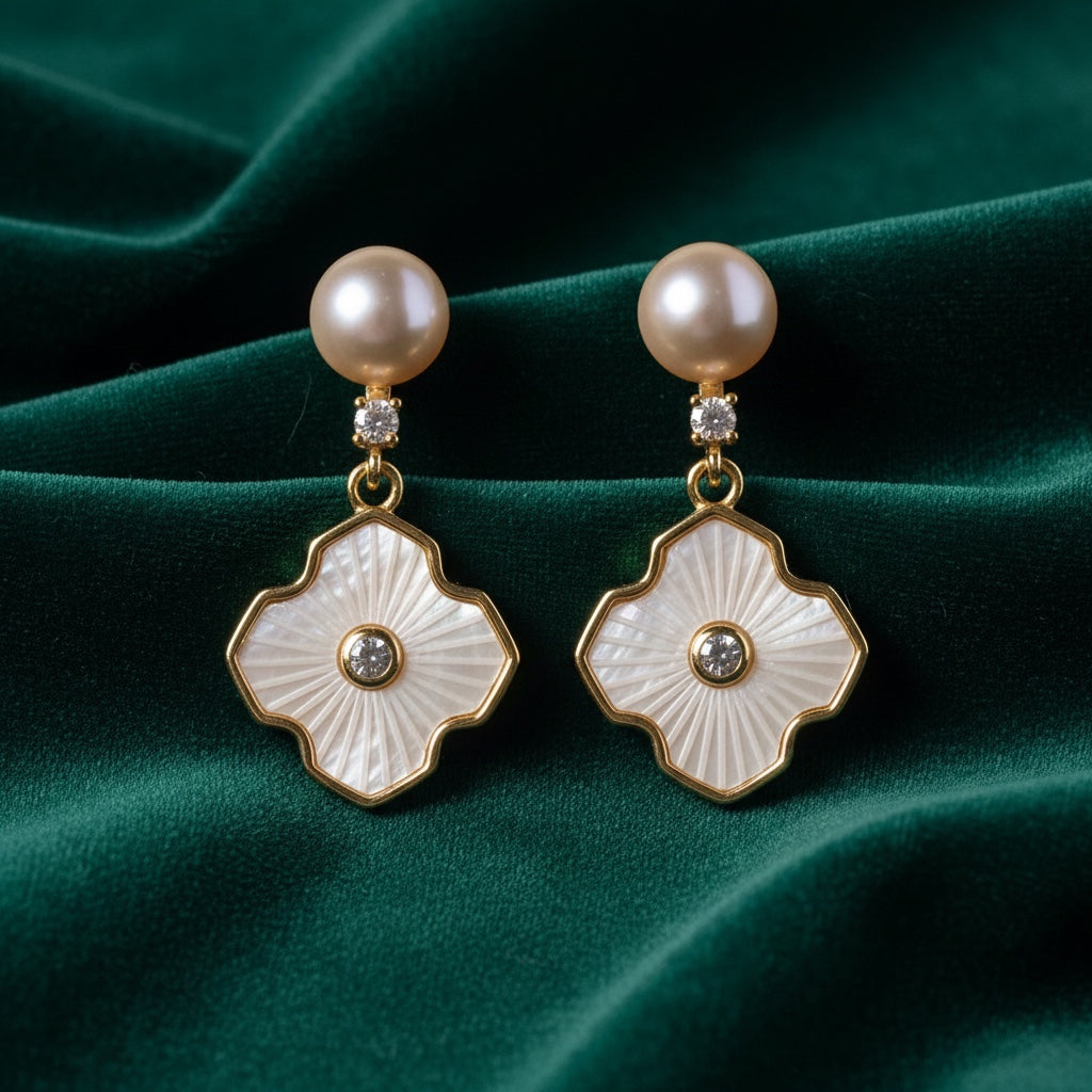 Charmluna gold drop earrings featuring cream pearls, quatrefoil mother-of-pearl charms, and sparkling crystal accents.