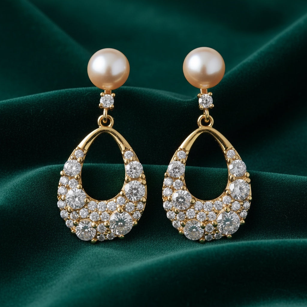 Charmluna teardrop pearl and crystal dangle earrings with gold-tone finish on dark green velvet background.
